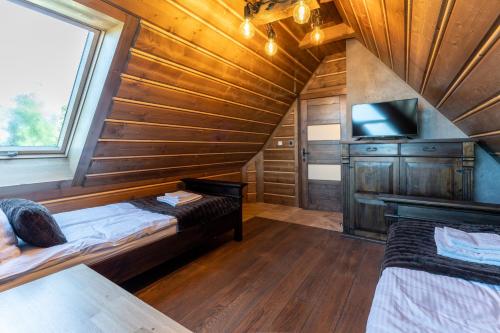 a room with two beds and a tv in a cabin at TatrApart in Zakopane