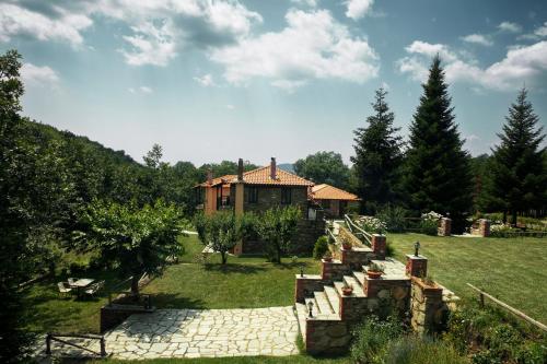 a house with a staircase leading to a yard at Guesthouse Rodamos in Taxiarchis