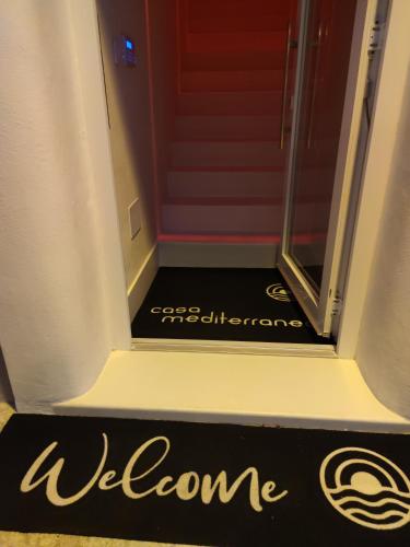 a welcome sign in front of a red door at Casa Mediterranea Jacuzzi vista Mare Torre Guaceto Ostuni in Specchiolla 