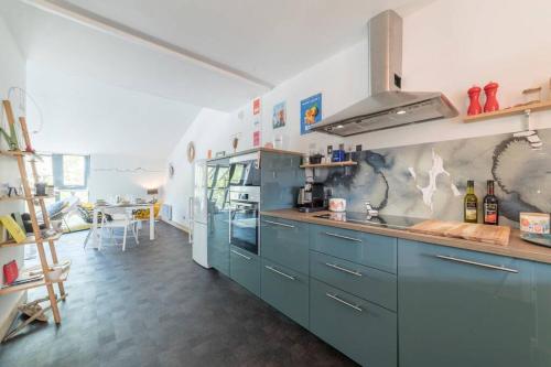 une cuisine avec des armoires bleues et un comptoir dans l'établissement le Gabut vue port, à La Rochelle