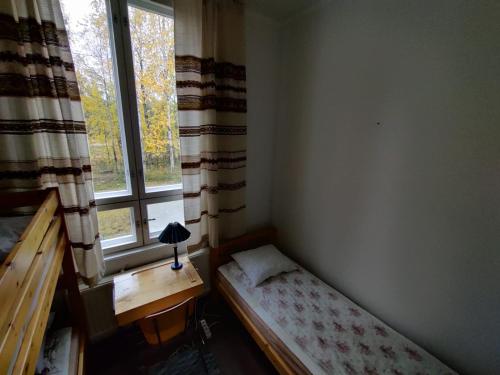 a small bedroom with a bed next to a window at Huoneisto Äkäsjokisuu - Lapin Linna in Äkäsjoensuu