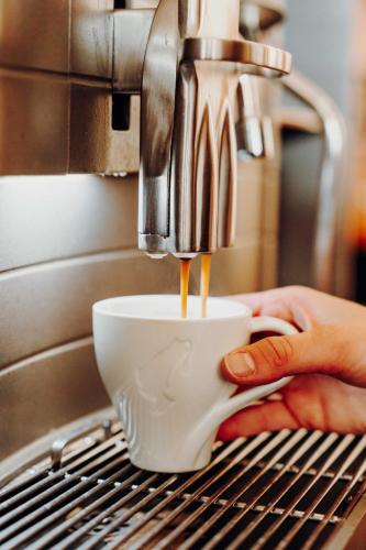 a person is making a cup of coffee at Hotel am Kapuzinerplatz in Knittelfeld