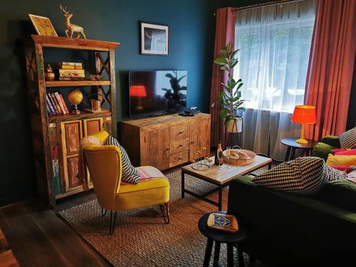 ein Wohnzimmer mit einem Sofa und einem TV in der Unterkunft Drumdelgie Cottages in Huntly