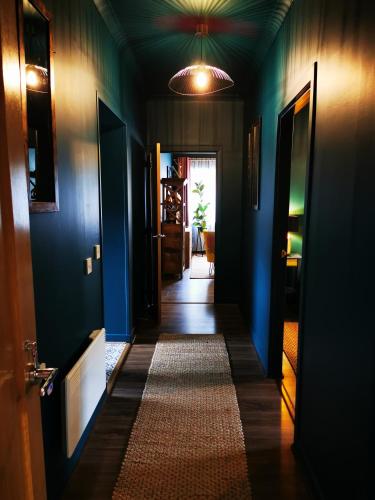 a hallway of a house with blue walls and a rug at Drumdelgie Cottages in Huntly