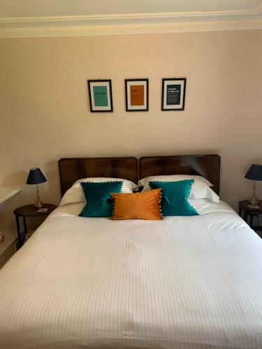 a white bed with three pillows on top of it at Leven House Bed and Breakfast in Crieff