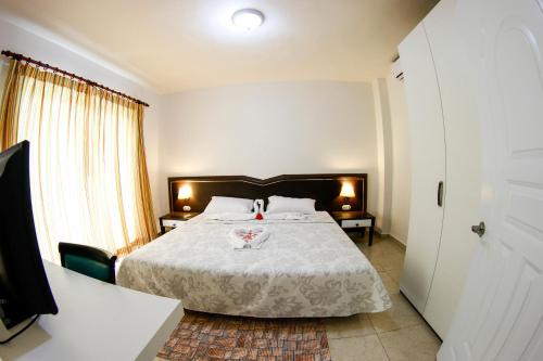 a bedroom with a bed with a white comforter at Kitewind Apartamentos Cabarete in Cabarete