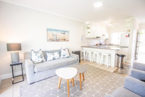 a living room with a couch and a table at Thirty River Club Villas managed by The Paper Fig House in Plettenberg Bay
