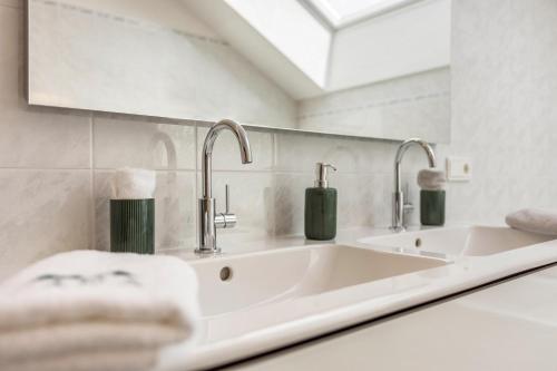 a white bathroom with two sinks and a mirror at Apt Lara Ruveda in Ortisei
