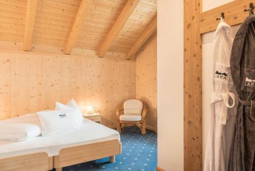 a bedroom with a bed and a chair in a room at Apt Lara Ruveda in Ortisei