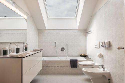 a bathroom with a toilet and a tub and a sink at Apt Lara Ruveda in Ortisei