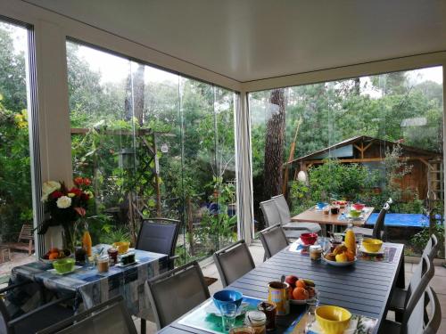 une salle à manger avec deux tables et une grande fenêtre dans l'établissement Le Relais de la Praya, à Lège-Cap-Ferret