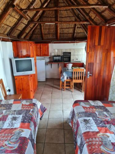 a room with two beds and a kitchen with a table at Arendsnes in Vanderbijlpark