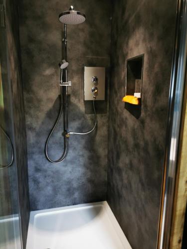 a bathroom with a shower with a tub and a sink at Drumdelgie Cottages in Huntly