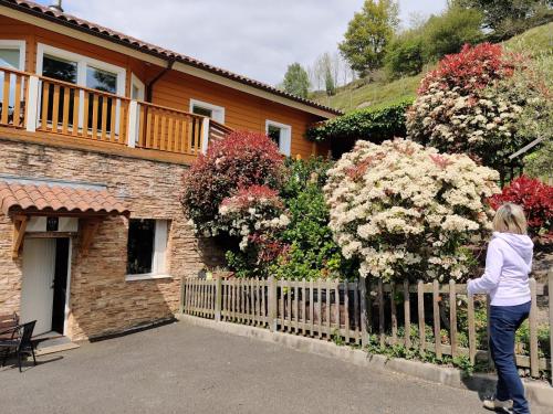 a woman standing in front of a house with a fence at Arbegain Etxea in Aizarna