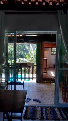 a room with a view of a room with a glass door at Chalé Vagalume Boiçucanga in Boicucanga
