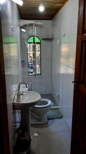 a bathroom with a toilet and a sink and a shower at Chalé Vagalume Boiçucanga in Boicucanga