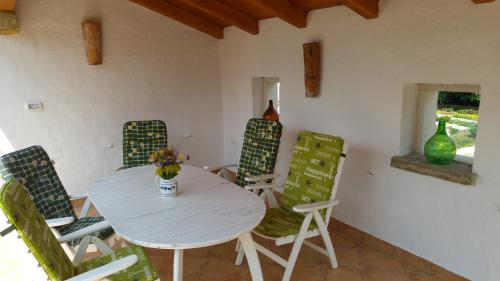 une salle à manger avec une table et des chaises blanches dans l'établissement Kmetija Jogan, Wines & Apartments, à Pobegi