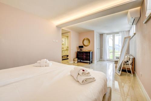 una camera da letto con un grande letto bianco con asciugamani di Villa Caterina a Salò