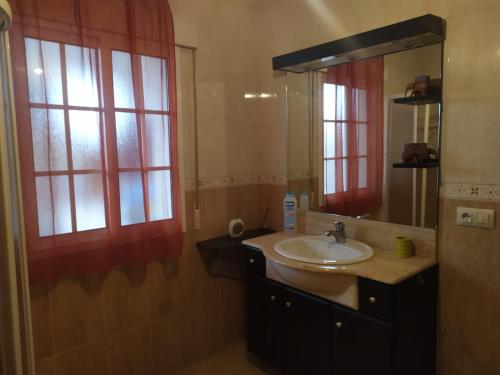 uma casa de banho com um lavatório e um espelho em El remanso de José em A Xesteira