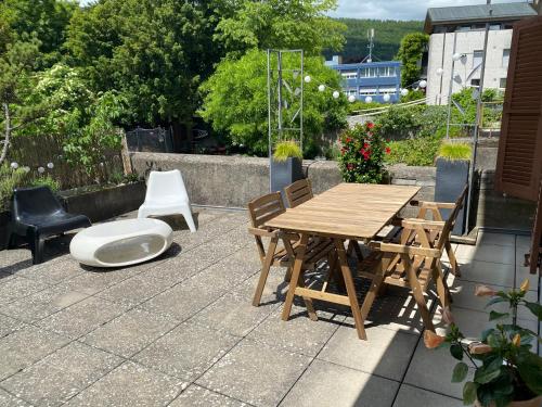 a wooden table and chairs and a toilet on a patio at Joline private guest apartment feel like home in Nidau