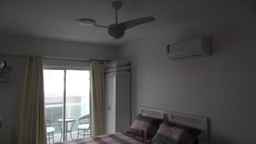 um quarto com uma cama e uma ventoinha de tecto em Belíssimo Apto à Beira Mar em Arraial do Cabo