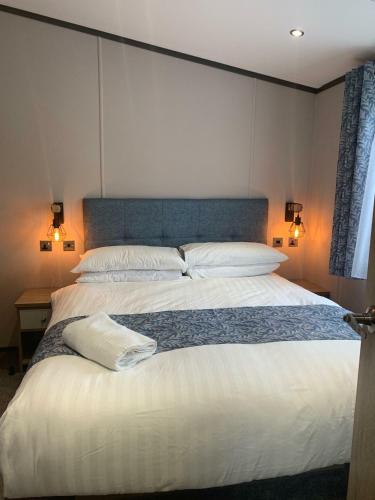 Barmby on the MoorにあるGraceland Lodge with Hot Tubの大きな白いベッドと枕が2つある寝室