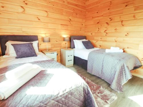 Postel nebo postele na pokoji v ubytování Bacheiddon Log Cabin