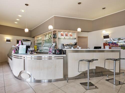 a restaurant with a counter and two stools at Parc Hotel Germano Suites & Apartments in Bardolino