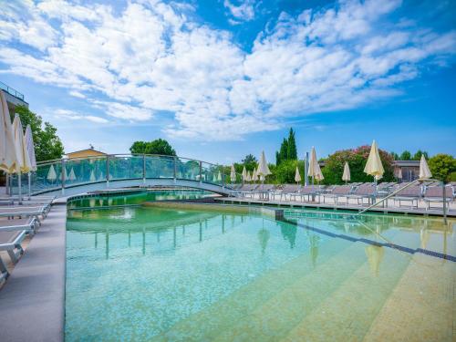 a large swimming pool with a bridge over it at Parc Hotel Germano Suites & Apartments in Bardolino