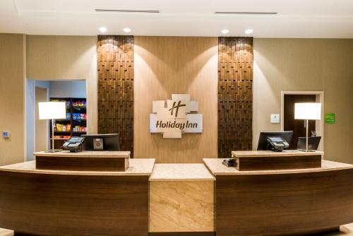 a hotel lobby with a reception desk with two laptops at Holiday Inn Paducah Riverfront by IHG in Paducah