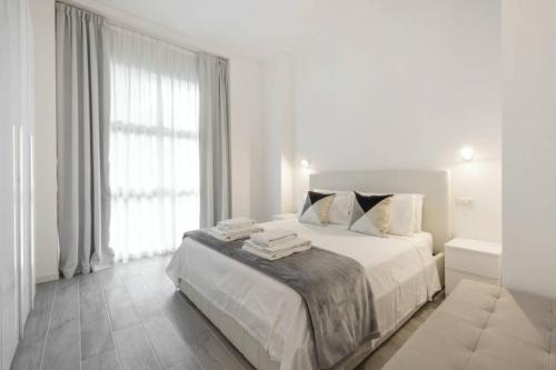 a white bedroom with a large bed and a window at Milan Royal Suites - Centro in Milan
