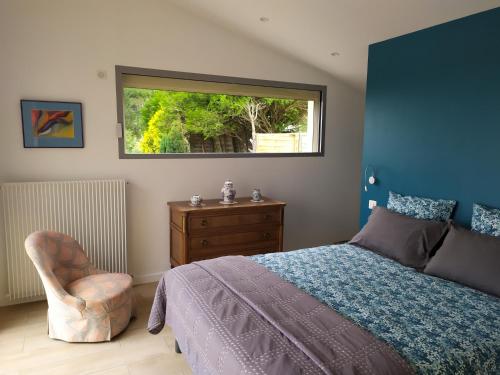 a bedroom with a bed and a chair and a window at villa Bouillat d'Anty in Châtel-Guyon