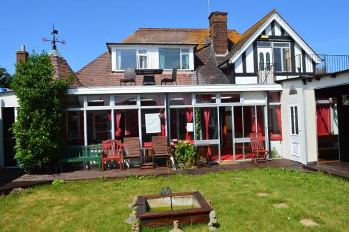 a house with a porch with chairs and a patio at Rossetti Lodge in Birchington