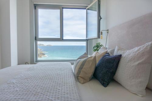 1 dormitorio con 1 cama y vistas al océano en Apt ILUKA Nuevo con vistas al mar, en Malpica de Bergantiños