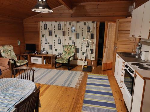 Holiday Cabin Kerimaa 103 في سافونلينّا: غرفة مع مطبخ وغرفة معيشة