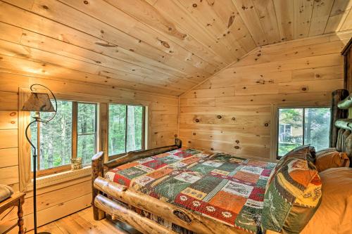a bedroom with a bed in a log cabin at Adirondacks Cabin with Fire Pit on Otter Lake! in Forestport