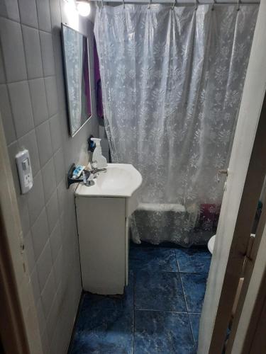 a bathroom with a sink and a shower curtain at Habitacion solo un huesped masculino hasta 25 años en casa de familia playa terminal centro wifi aire in Mar del Plata