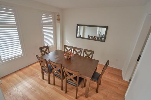 mesa de comedor con sillas y espejo en la pared en Entire house for your getaway!, en Carrying Place