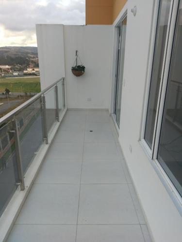 a balcony of a white building with a basket on the wall at MIRADOR TUNJA 401 in Tunja