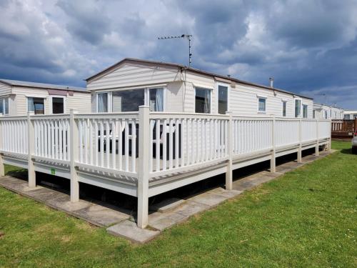 a white mobile home with a white fence at 8 Berth on The Chase Ingoldmells Nordstar in Skegness