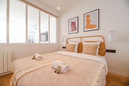 a bedroom with a large bed with two towels on it at MBM - LOFT MARAIS in Paris
