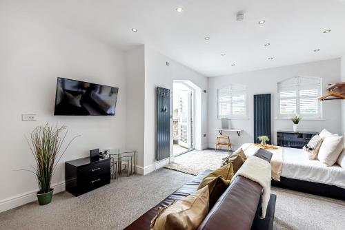 a bedroom with a bed and a tv on a wall at Locket Studio - Cosy Apartment with Balcony in York