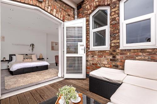 a room with a brick wall and a bedroom at Locket Studio - Cosy Apartment with Balcony in York