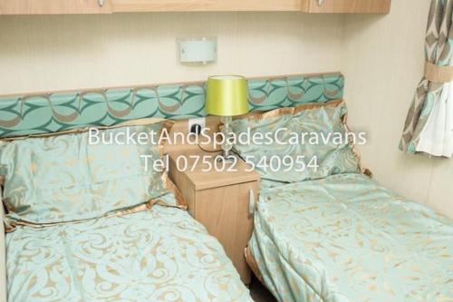 a bedroom with two twin beds and a yellow lamp at Blackpool caravans Marton mere in Blackpool