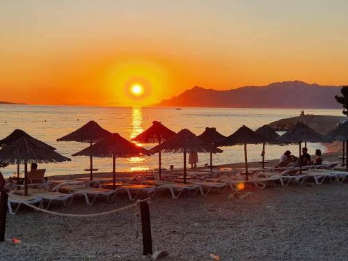 a beach with umbrellas and people sitting on the beach at The best location in Makarska,free P, option bikes in Makarska
