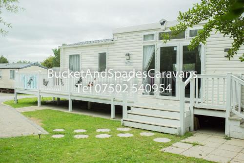a white mobile home with a large porch at Blackpool caravans Marton mere in Blackpool