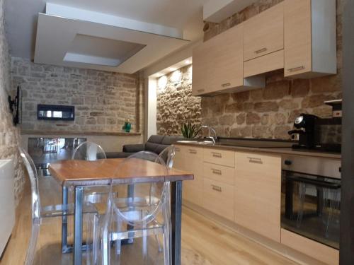 a kitchen with wooden cabinets and a table and chairs at Appartamento Gattapone 9 in Gubbio