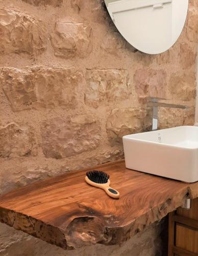 a bathroom with a sink and a brush on a wooden counter at Appartamento Gattapone 9 in Gubbio