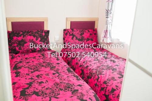 a bedroom with a pink bed with pink sheets at Blackpool caravans Marton mere in Blackpool