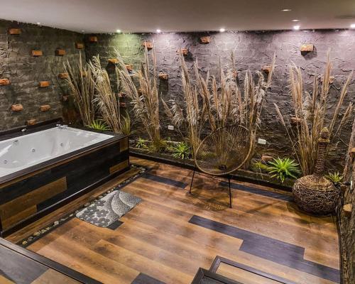 baño con bañera y algunas plantas en Polylepis Lodge en El Ángel
